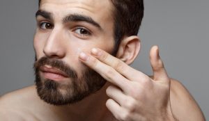 Man with beard applying skincare